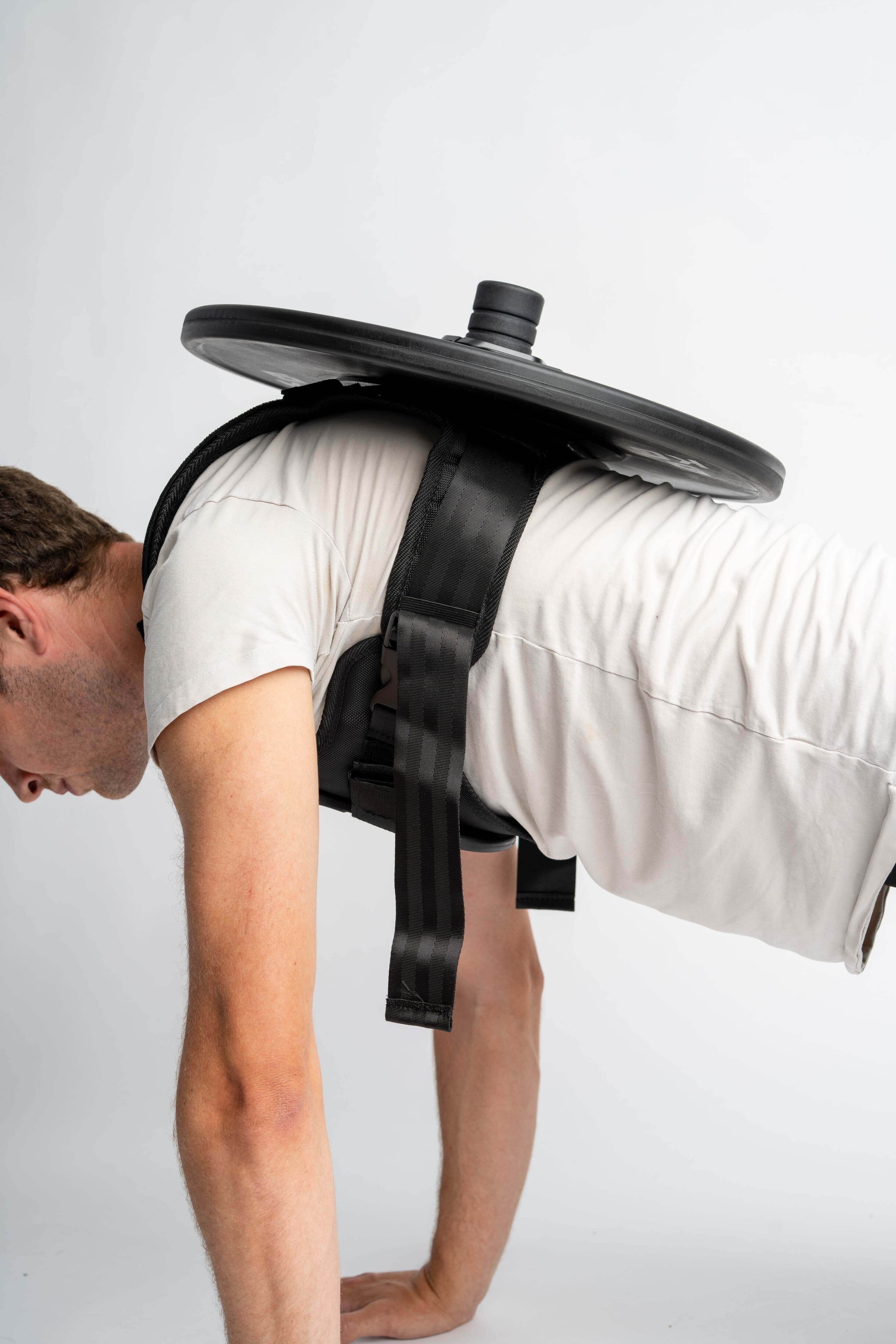 Verstellbare Gewichtsweste bis 75 kg mit einer Hantelscheibe für zusätzlichen Widerstand beim Training.